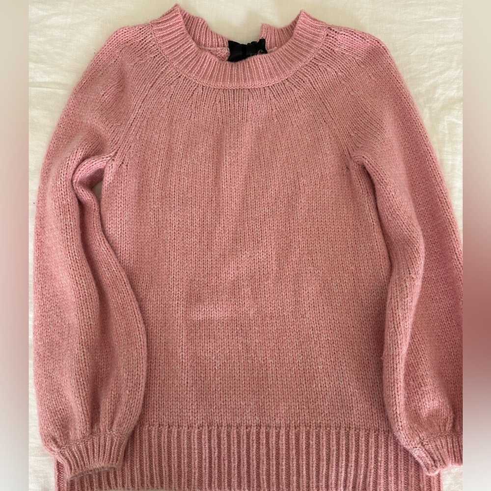 Light pink knit sweater with black silk bow in the back